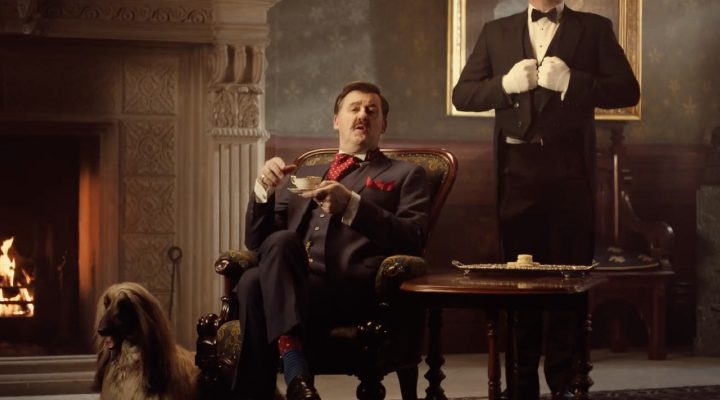 NobleOak's Nobleman sits on a chair, with a cup of team in hand, while his butler stands at this service next to him