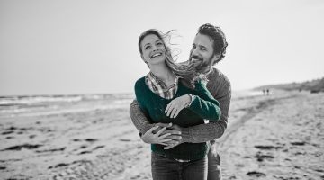 Young couple share playful embrace on an Australian beach