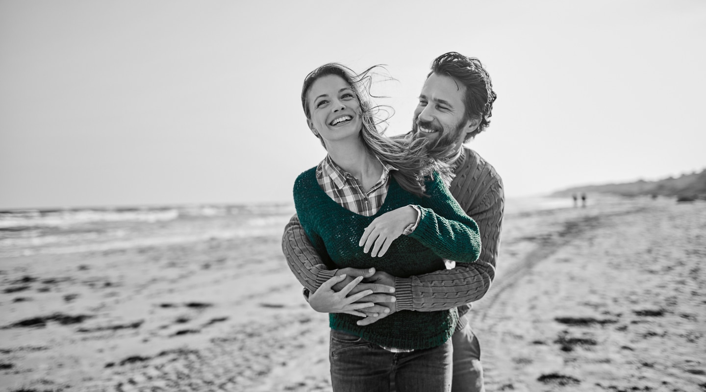 Young couple share playful embrace on an Australian beach